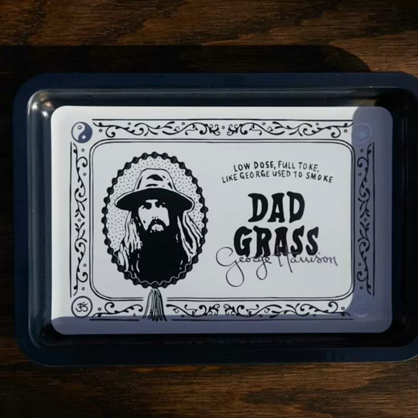 A printed metal rolling tray on a dark wooden table