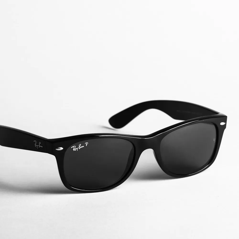 Black square frame sunglasses on a white surface