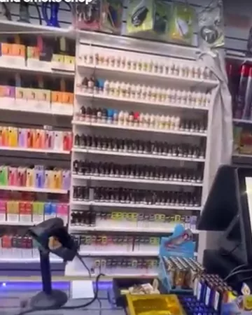Shelves of disposable vapes and e-liquid bottles behind the counter