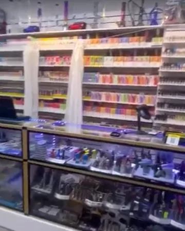 Vape and e-liquid shelving above the long glass counter