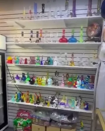 Glass water pipes and hand pipes on a white slatwall