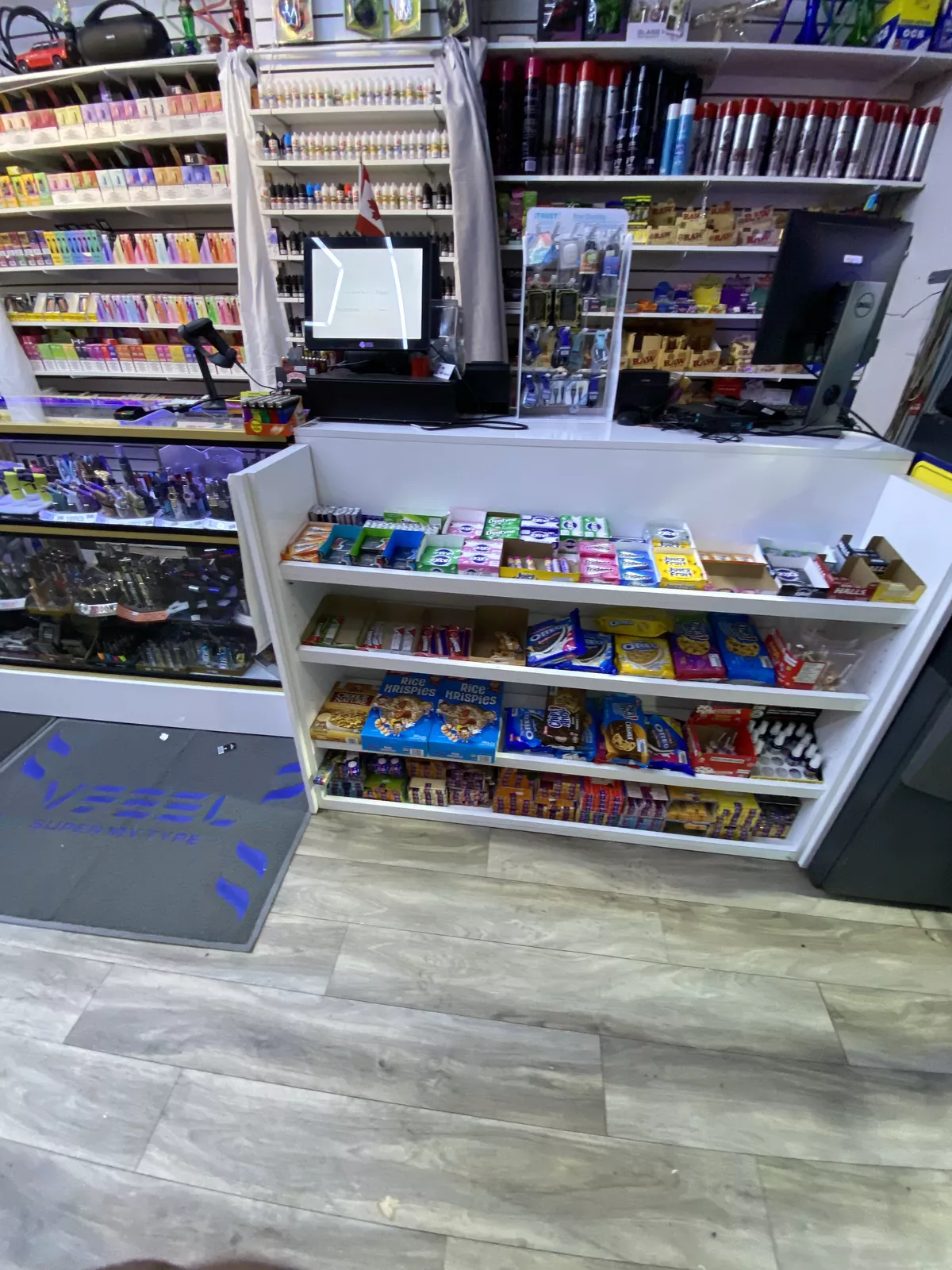 The counter, with the disposable vape wall and e-liquid shelves behind it